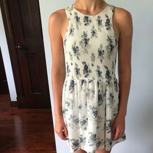 A white mini dress with blue flower detailing.